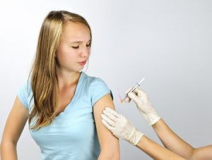 10637543 - teenage girl getting flu shot needle vaccination in arm
